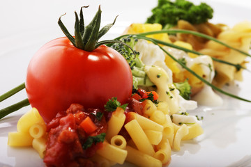 A prepared plate of spaghetti broccoli ready for serving garnished with tomatoes and basil