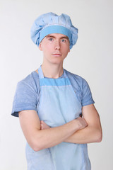 young cook in uniform on white background