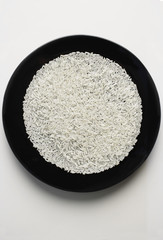 uncooked grains of rice spread out on a black plate