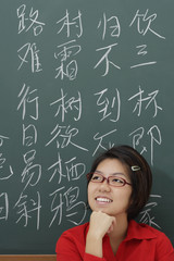 woman standing in front of chinese characters written in chalk