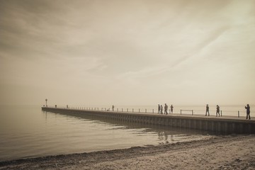 People walk out onto a dock on Lake Michigan