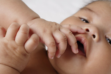 Close up of hands on babies mouth.