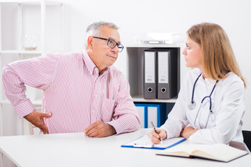 Patient is telling doctor about his health problems. He is having pain in his back.