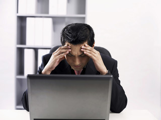 man using laptop feeling stressed up