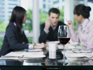 Three people talking at end of table