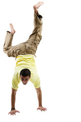Young man balancing on his hands, legs up