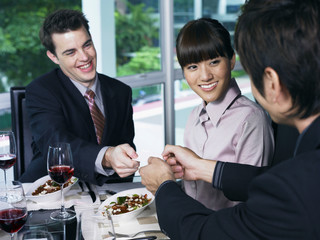 business men exchanging cards while woman looks on