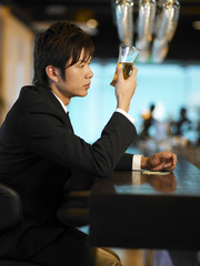 man at bar staring at drink