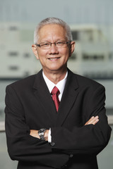 mature man with grey hair wearing a suit and smiling