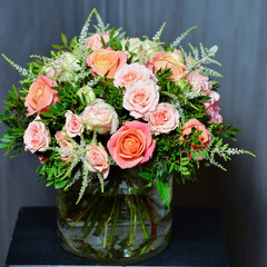 Bouquet with cream and pink roses in a glass vase