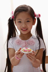 young girl with pony tails holding cookies