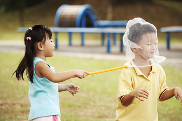 Fototapeta premium girl catching a boy with butterfly net