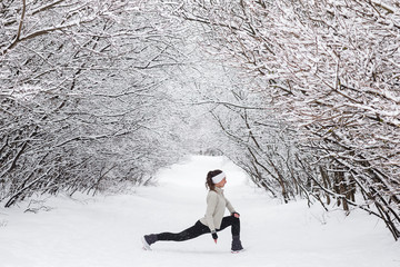 Young woman doing stretching exercises during winter