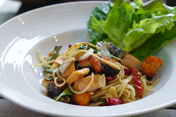 Salmon and onion spaghetti serving with fresh salad