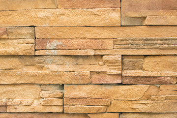 Brown wall lined with stone tile, background, texture