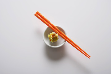 dim sum in bowl with orange chopsticks
