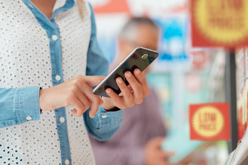 Woman shopping and using her phone