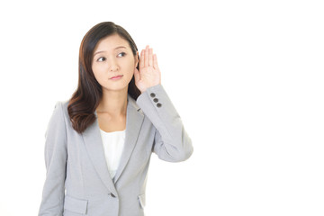 耳に手を当てる女性