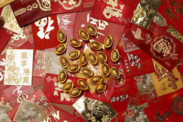 Gold money, ingot scattered on red packets or Hong Baos