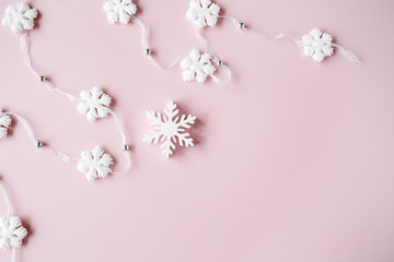 Fototapeta na wymiar white christmas snowflakes decoration on pink background. christmas wallpaper. flat lay, top view