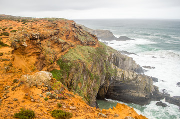 Cliffs near the Atlantic ocean coast in cloudy rainy day in Alentejo, Portugal