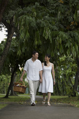 Fototapeta na wymiar Singapore, Man and woman walking through park