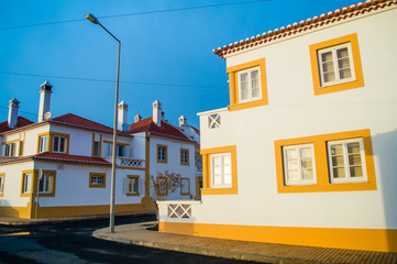 Traditional yellow and white houses in Zambujeira do Mar village, Alentejo, Portugal