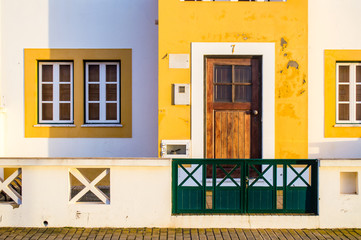 Traditional yellow and white houses in Zambujeira do Mar village, Alentejo, Portugal