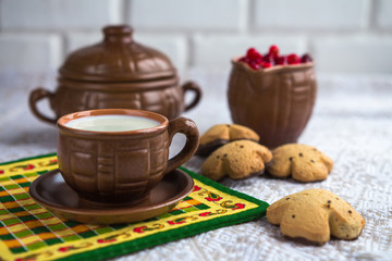 Breakfast in a rustic style, milk, biscuits, fruit in pottery