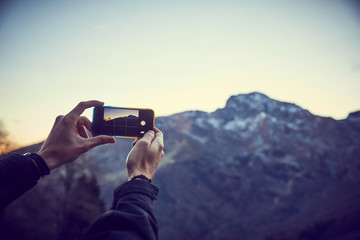 Ragazzo scatta foto in montagna con smartphone