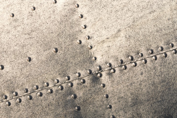 Old metal silver surface of the aircraft fuselage with rivets