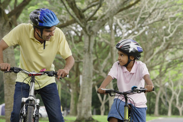 Obraz premium A father and son ride their bikes together