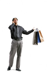 Businessman talking on mobile phone, carrying shopping bags