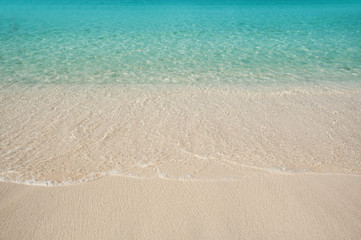 Fototapeta na wymiar Sandy Beach and blue water of the sea