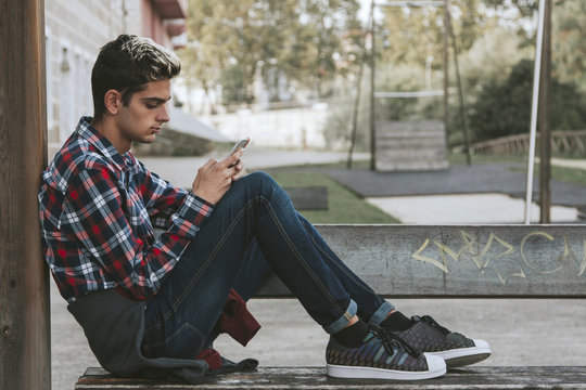 Teenager Boy With Mobile Phone In The City