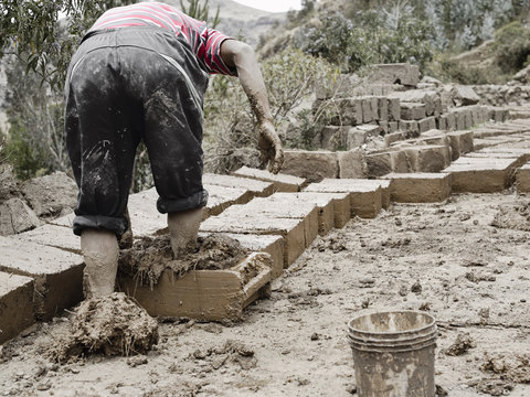 Boy making traditional adobe mud bricks in Paru Paru Community V