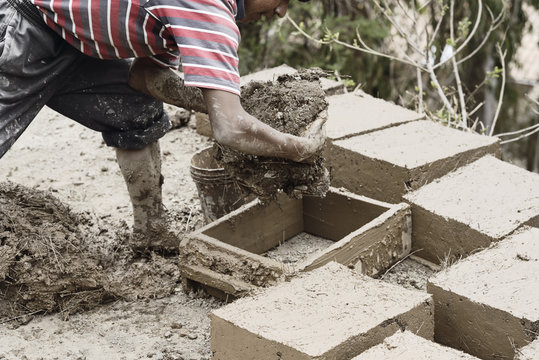 Boy making traditional adobe mud bricks in Paru Paru Community V
