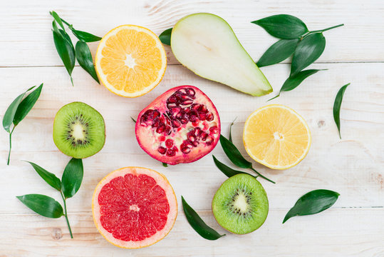 sliced fruit on wooden white background, top view