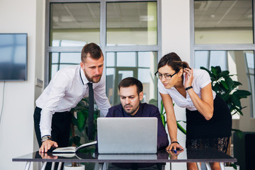 beautiful young business woman and businessmans in headsets using laptops while working in office