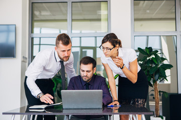 beautiful young business woman and businessmans in headsets using laptops while working in office