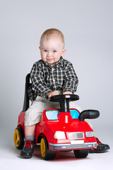 little boy driving toy car