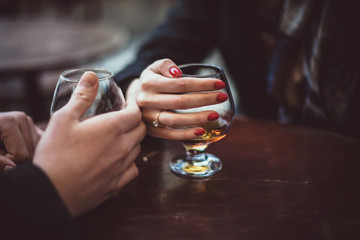 hands of men and women with cognac