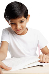 Boy looking at book and writing