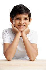 Boy with hands on chin, smiling