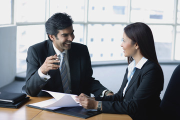 Businessman and businesswoman in office, having a discussion