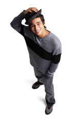 Man with hat standing with hand in pocket, looking up at camera