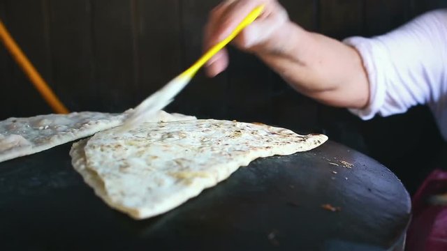 Granny chef cook Turkish pancake Gozleme on the stove