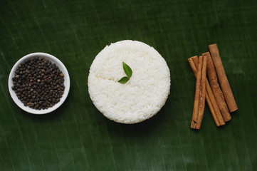 Still life of cinnamon sticks, black pepper and basmati rice