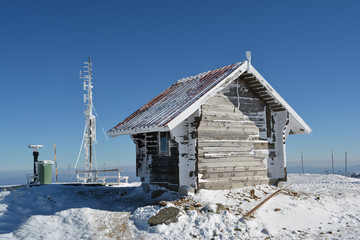 Fototapeta na wymiar Small log house, frozen antenna and a few other stuff