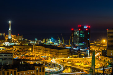 Fototapeta na wymiar GENOA, ITALY OCTOBER 30, 2016 - Industrial area near the port with Lanterna and commercial skyscrapers at night
